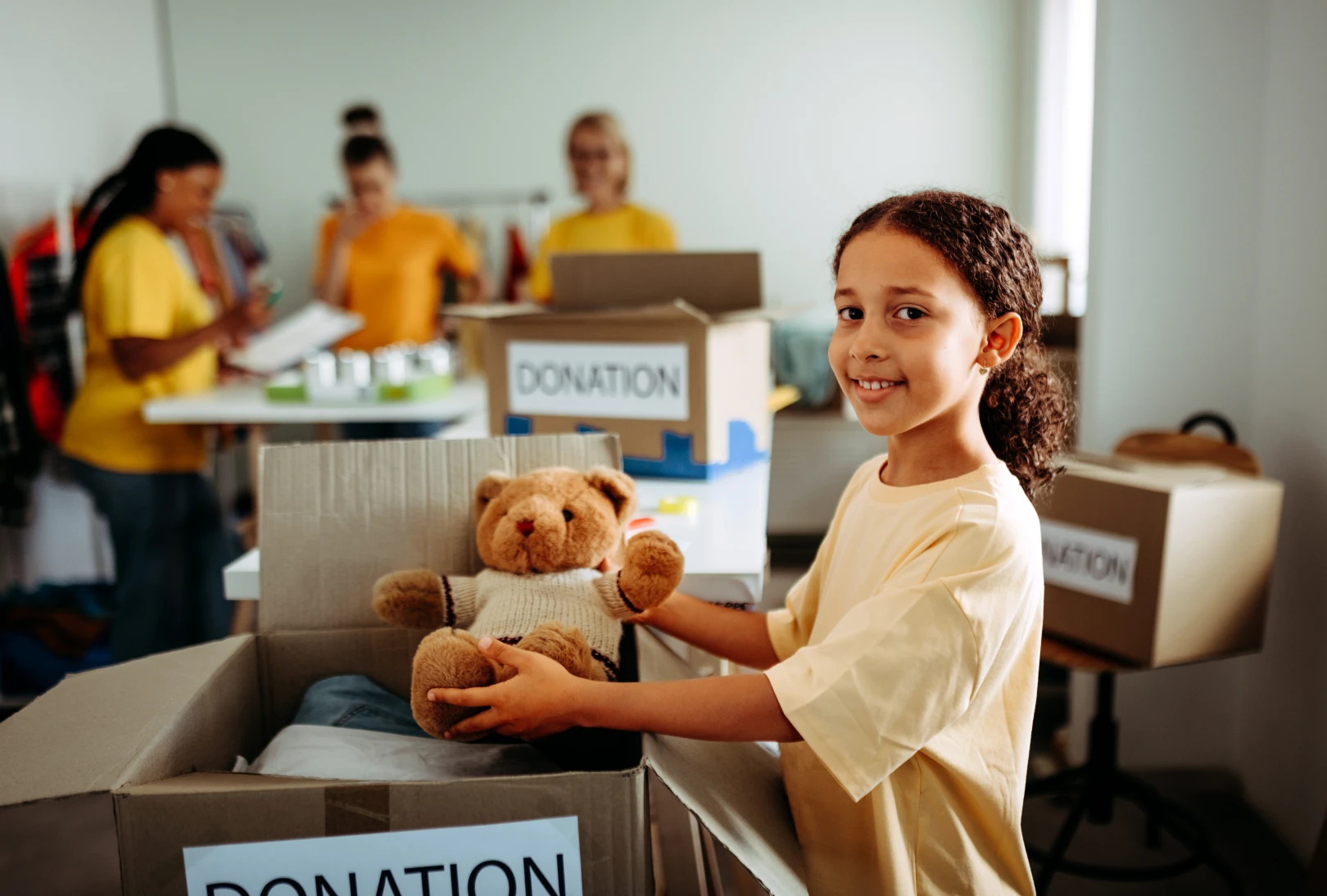 Child holding teddy bear at donation center